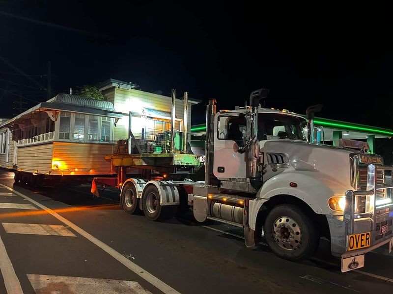 House on a truck travelling under streetlights at night